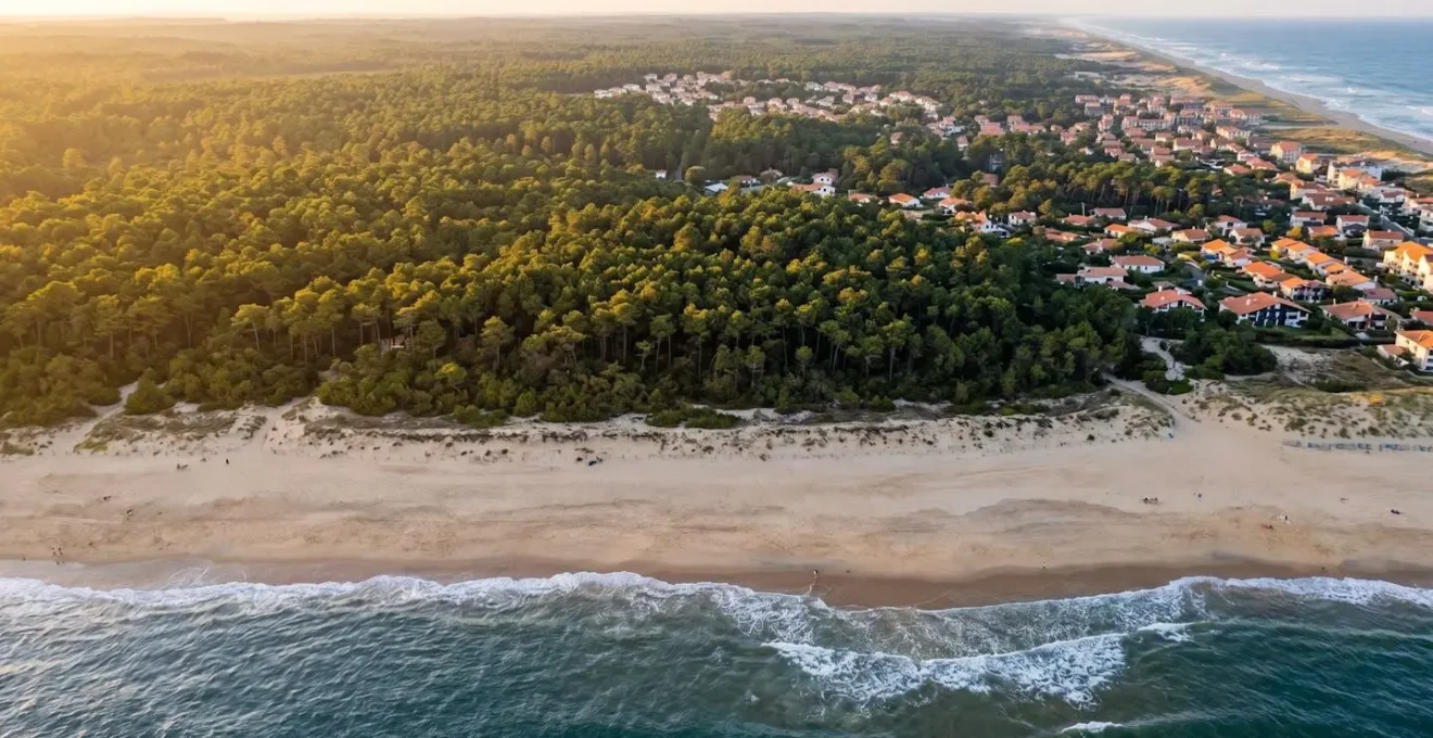 Vue aérienne du littoral landais montrant la succession océan Atlantique, plage de sable, forêt de pins maritimes et zone résidentielle